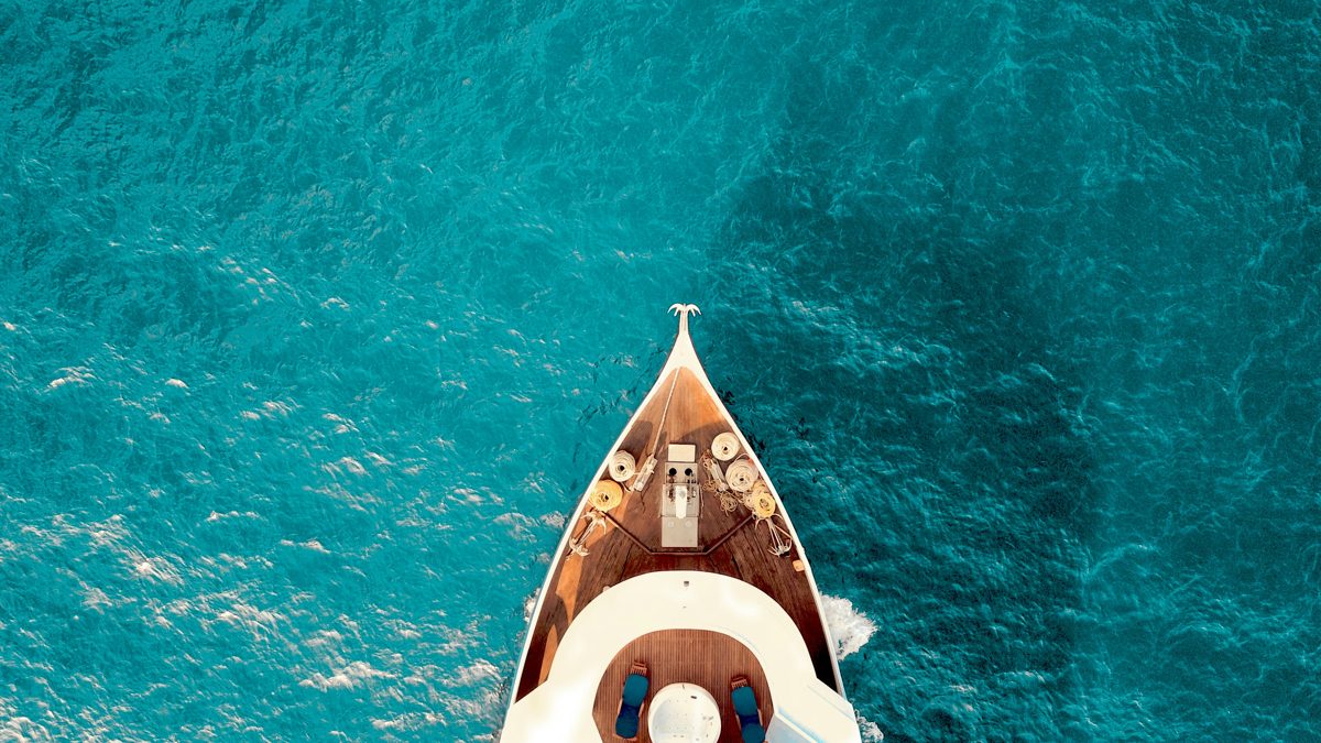 Bow of a yacht cutting through blue water